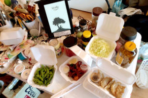 Takeout gyoza, edamame, kindle on a Messy desk