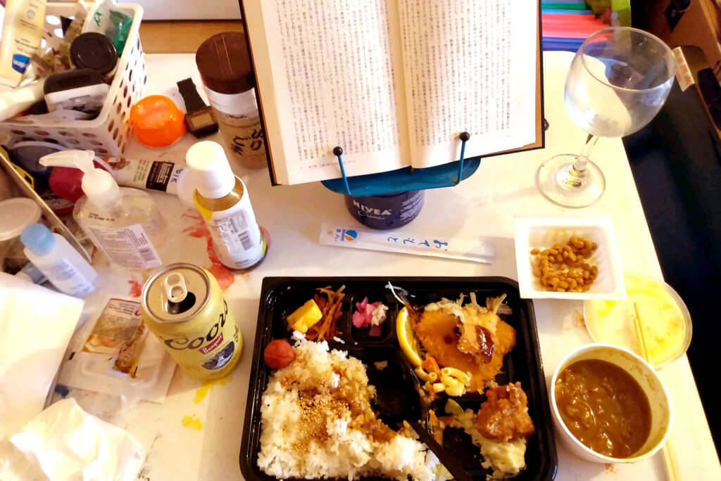 Aji fried bento, Curry sauce, beer and a bookon on the messy table in Torrance