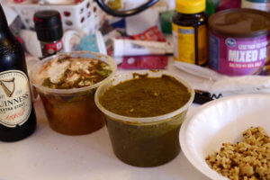 Indian curry sauce and a bottle of Guiness beer on the messy table