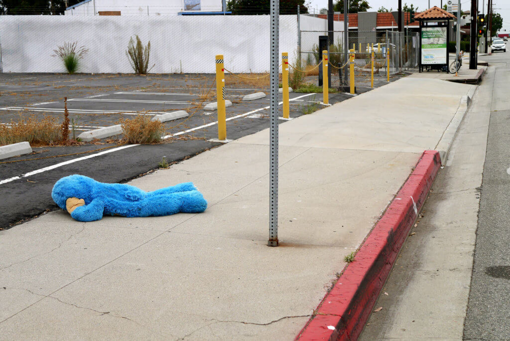 The blue stuffed animal lying down on the roadside in LA