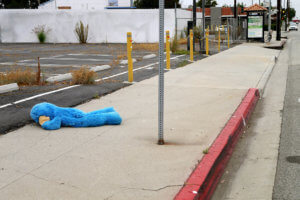 The blue stuffed animal lying down on the roadside in LA