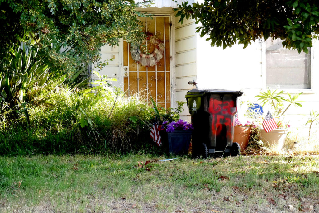 American house yard, there is a bin and national flag in the US California
