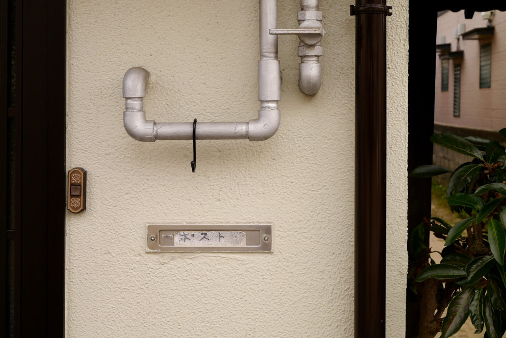 Post on the house wall and pipes