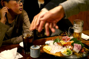 Japanese sashimi and a boy at izalaya Umibozu in Hiroshima Japan