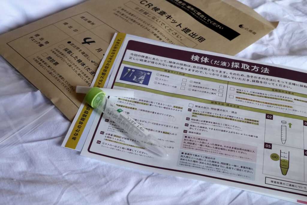 saliva type PCR test kit on the hotel bed