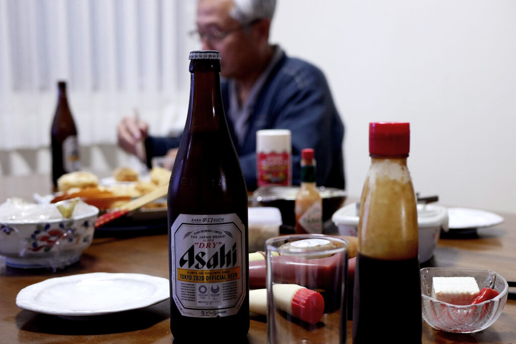 Asahi beer on the table on the table and behind is my father