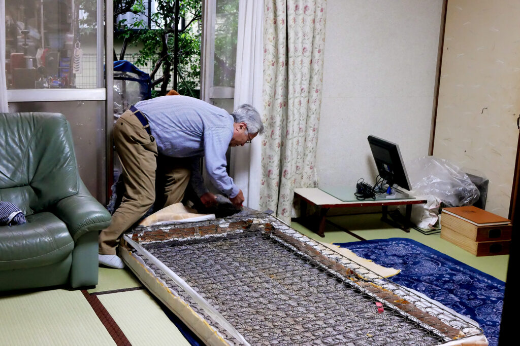 A elder man is dismantling the bed mat in Japan