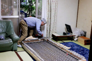 A elder man is dismantling the bed mat in Japan