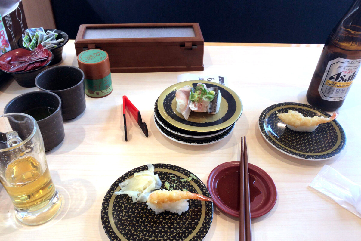 Hama-zushi Sushi plates and a bottle of beer on the table at Hama-zushi