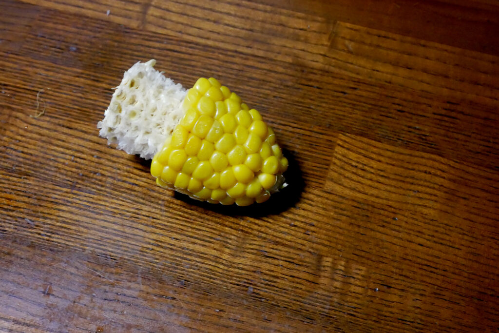 Boiled corn bitten in the shape of a penis on the table