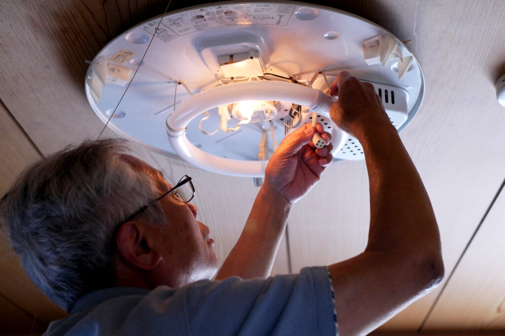 Image of an old father fixing a broken the body of light