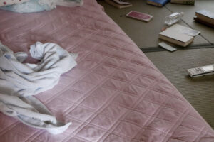 Messy futon mat on traditional Japanese tatami mat