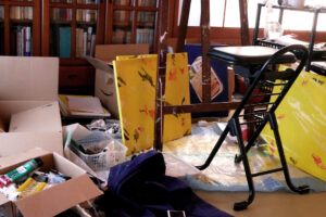 There are paintings, a chair etc. Japanese artist's messy studio in Hiroshima Japan