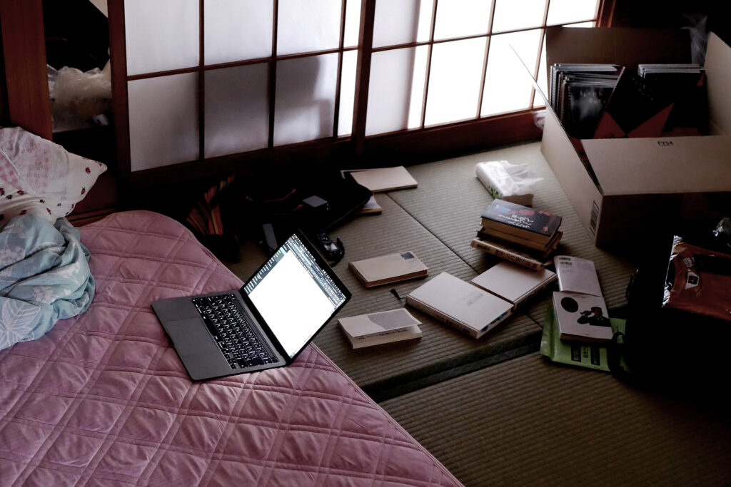 MacBook Pro on the futon and messy tatami mat room