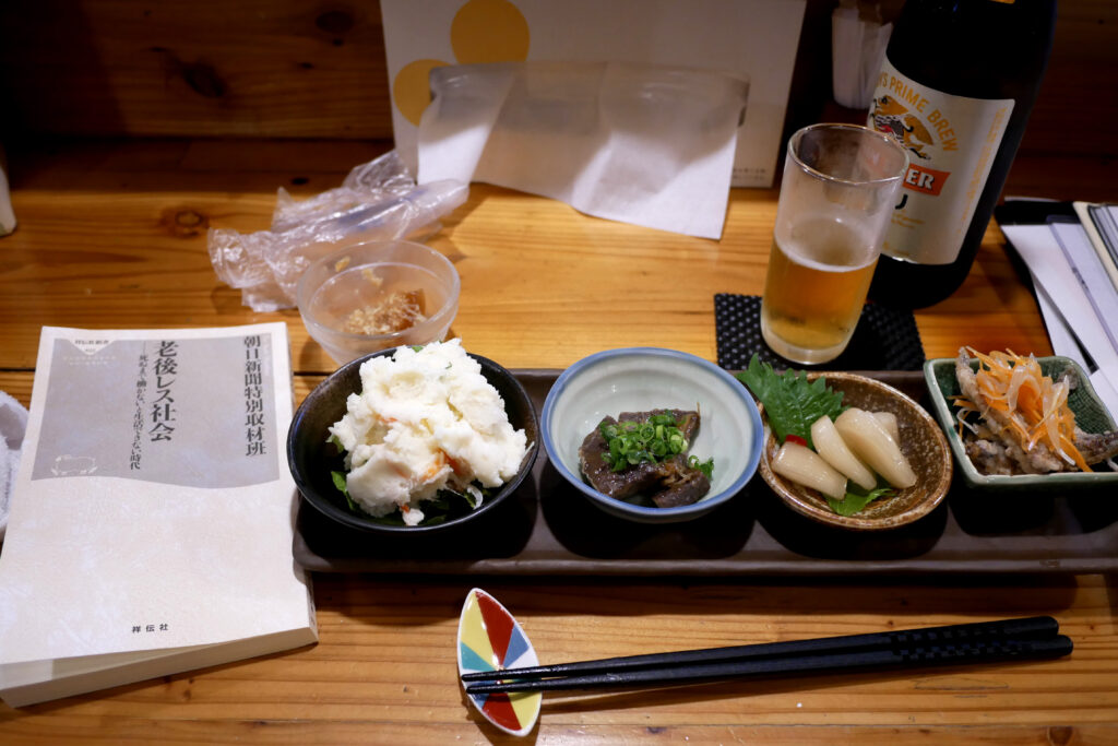 Japanese Izakaya small dishes and a Japanese book on the wooden table