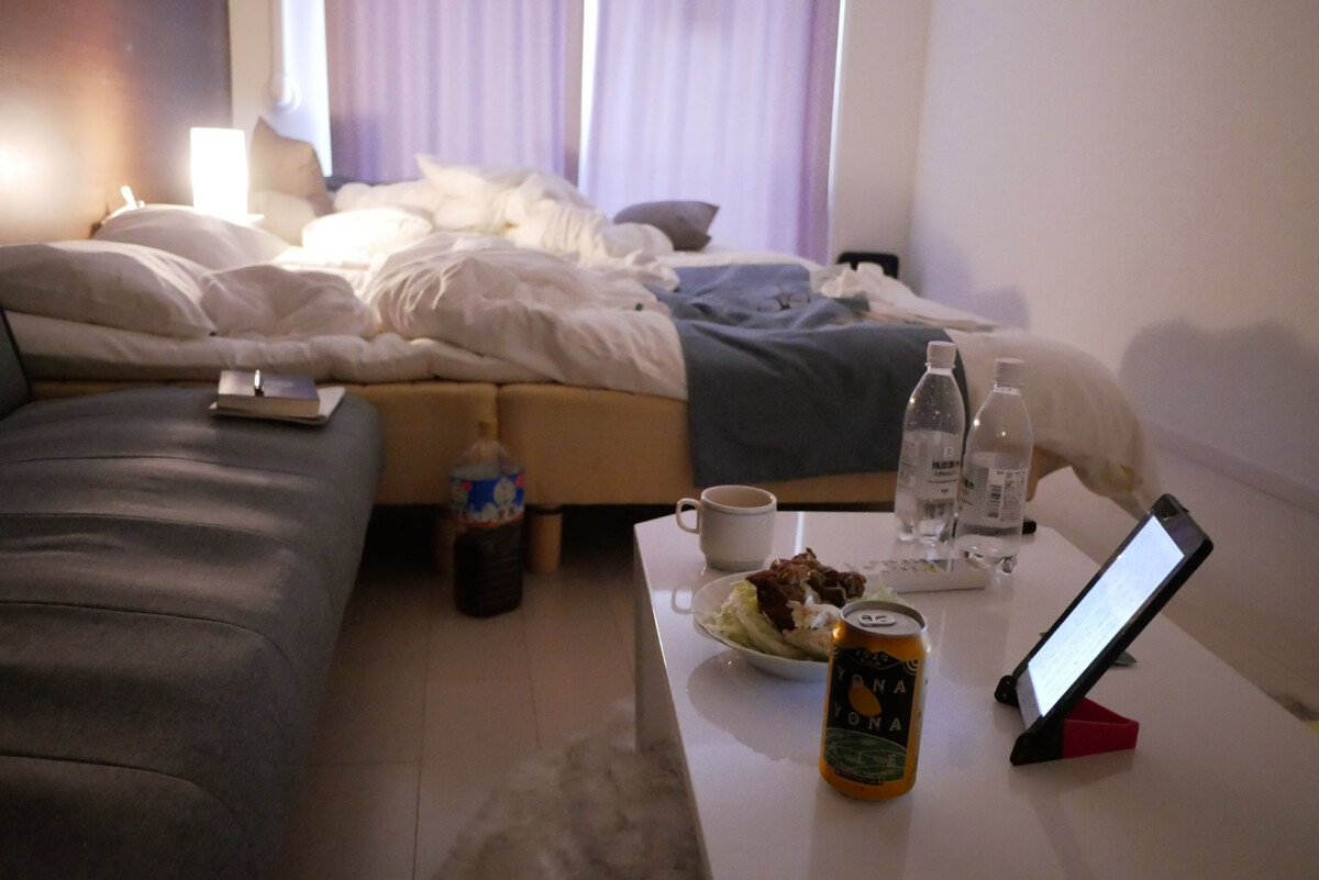 Ouchi hotel room two beds, food and canned beer on the table in the evening at my home like hotel room in Hiroshima Japan