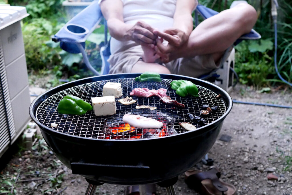 Beef, bell peppers etc on the Charcoal Grill at yard, there is a man's legs in Japan