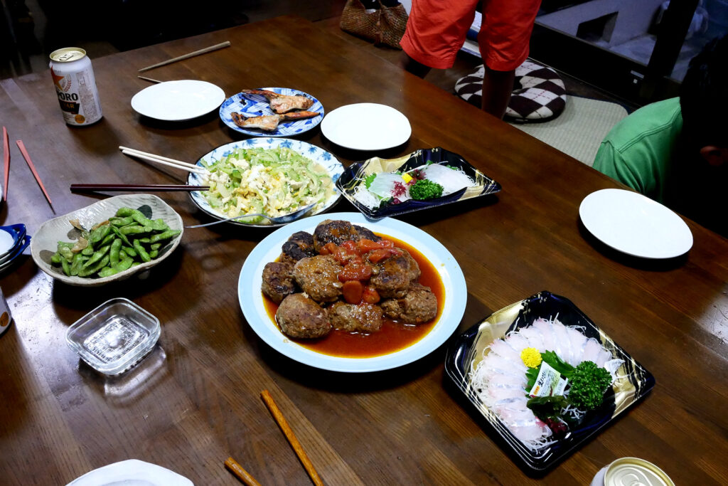 Japanese dinner like sashimi, fried goya, hamburger steak on the wooden table