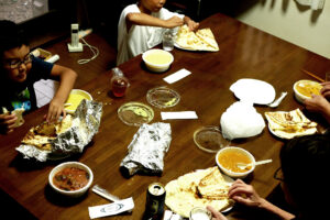 A Japanese family member are eating Indian curry and naan on the table