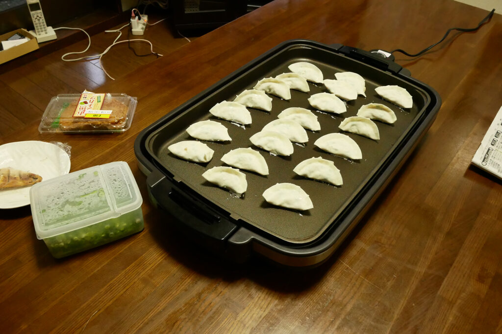 Japanese hand maid gyoza on the electrical plate on the wooden table