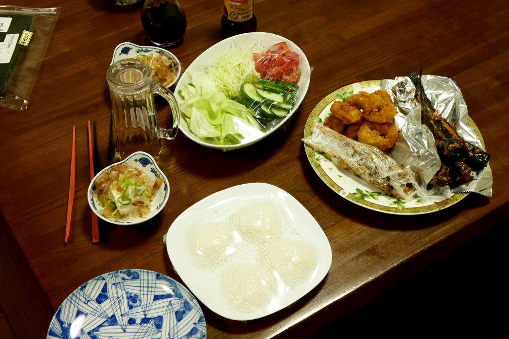 Salad, grilled fish, rice ball such Japanese daily dishes on the wooden table