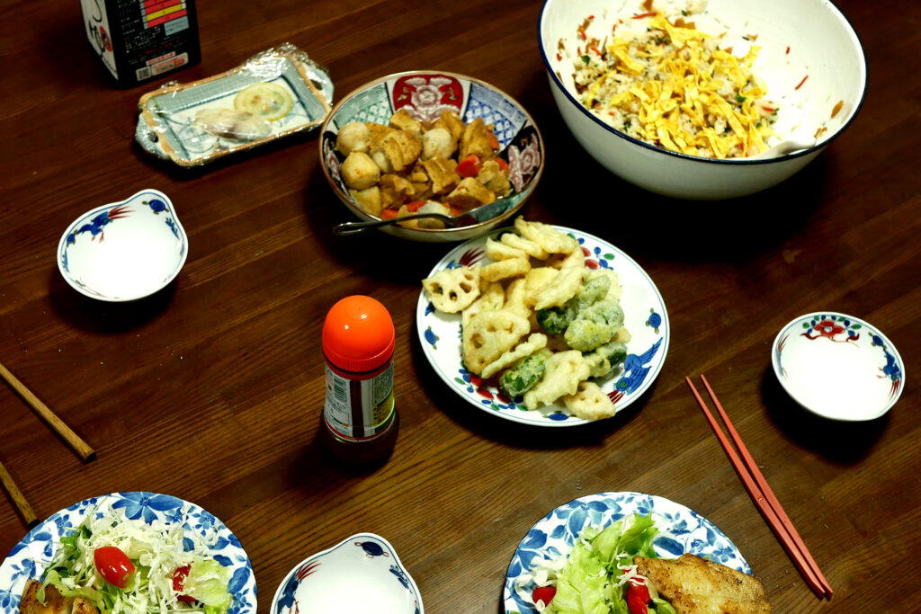 Japanese dishes like tempura, chirashi sushi on the table