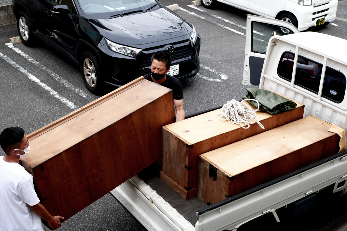 Moving a chest Men are moving a chest on the lightweight truck