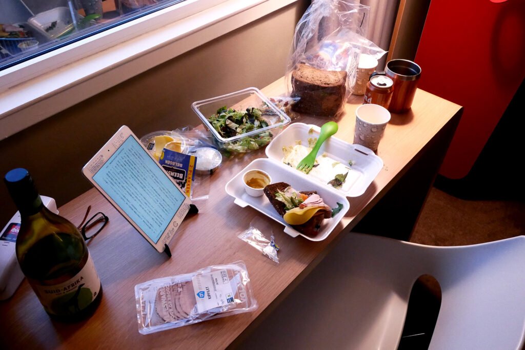 Packed meal and iPad on the wooden table in the hotel room