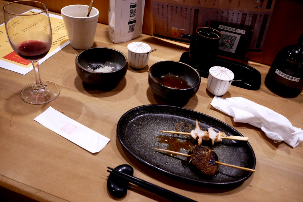 Japanese yakitori dishes, wine on the wooden counter table