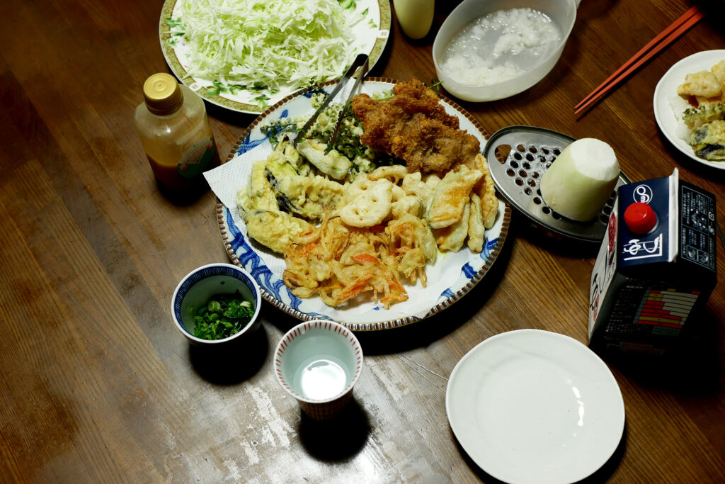 Variety of Tempura on the plate, shredded cabbage ion the wooden table