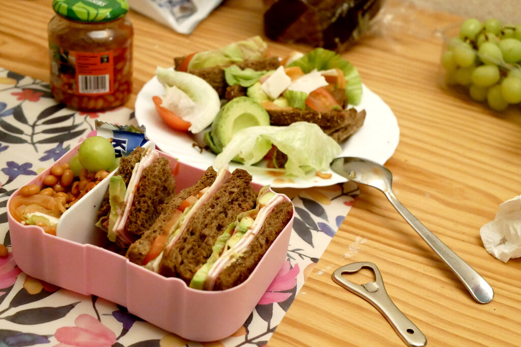 Bento sandwiches, packed grapes on the wooden table