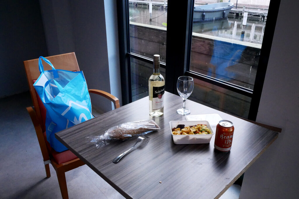 Bread, packed Indonesian food, a bottle of white wine on the table in the Netherlands