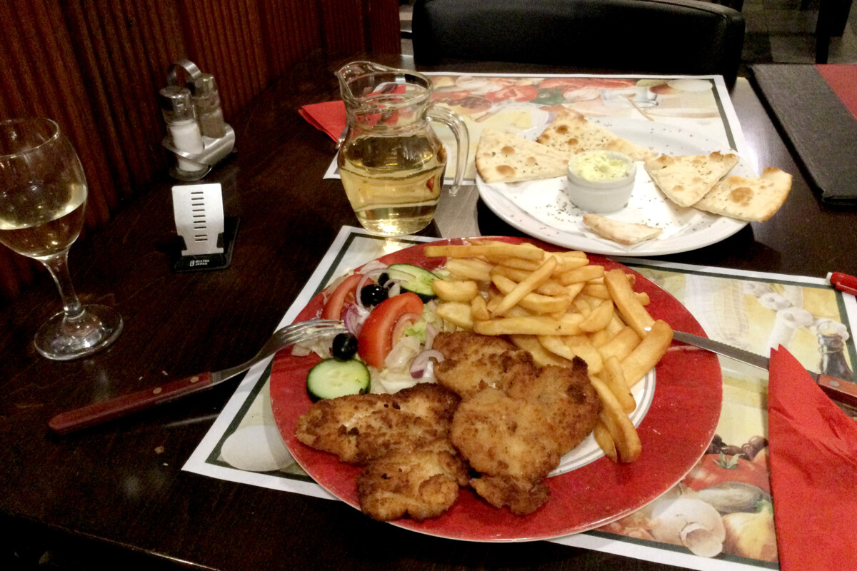 Italian dinner White wine, chicken, fried potatoItalian dinner on the table