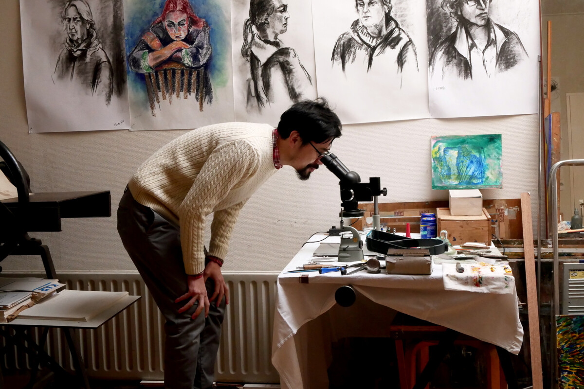 A man looking microscope at a painter's studio in Castricum Netherlands