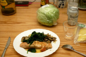 Salomon Meuniere on the plate, a whole lettuce on the wooden table