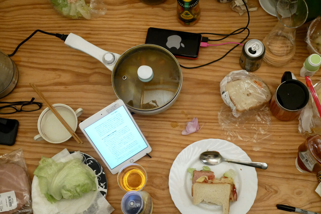 iPad, hot pot, plate one the messy wooden table