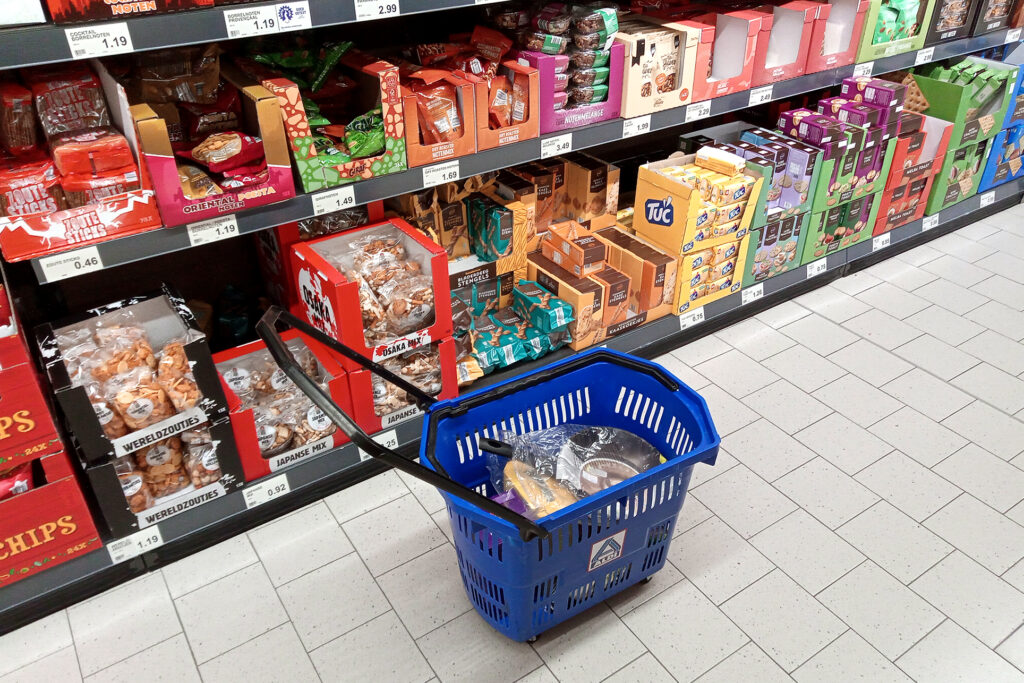 A shopping cart on the floor, there are products in the supermarket in the Netherlands