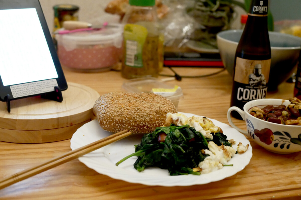 Bread, spinach with mushrooms and fried egg on the plate, kindle on the wooden table