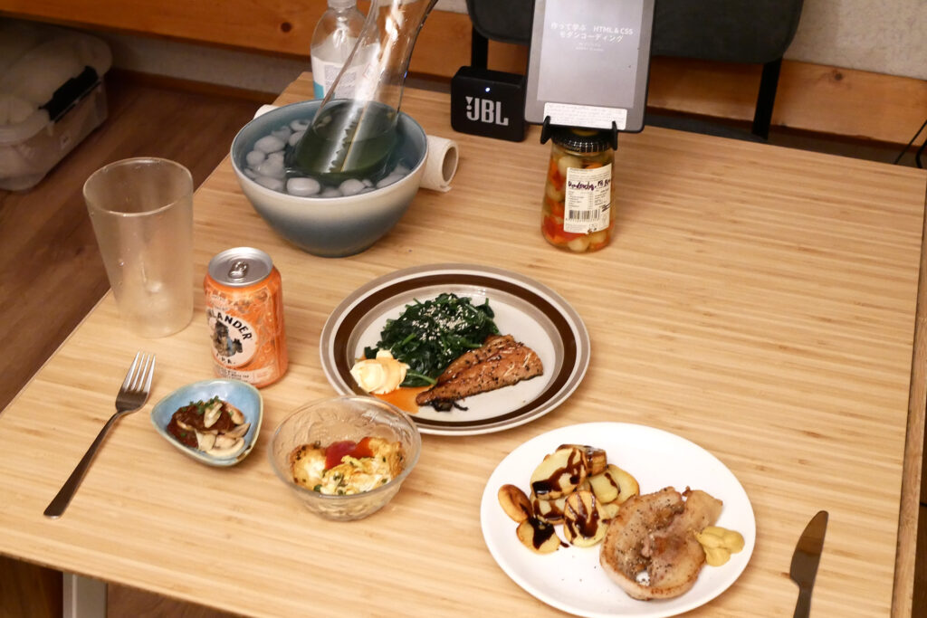 pork steak, smoked mackerel and spinach dishes on the home wooden table