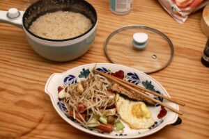 Cooked rice pan and stir fried veggies and an egg