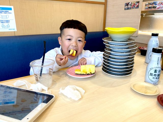 A kid eating food at Hama Zushi restaurant in Hiroshima