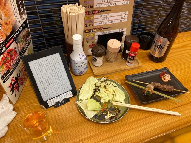 Izakaya counter table, there are cabbage, yakitori, and kindle book