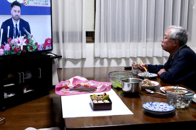 Japanese home dinner, an old man eating food while watching TV