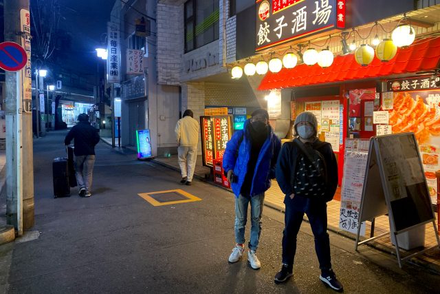Mens stand on front of izakaya Gyoza sakaba in Japan Tokyo Ogikubo