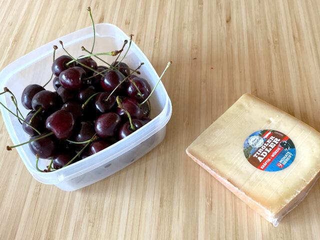 Cherry and cheese on the wooden table