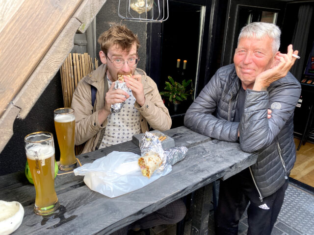 A Dutch man is eating Turkish pizza in the bar in the Netherlands