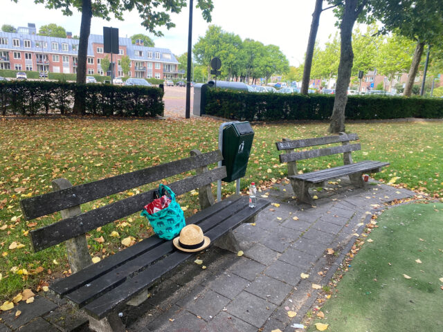 A hat and bag on the bench at the green park