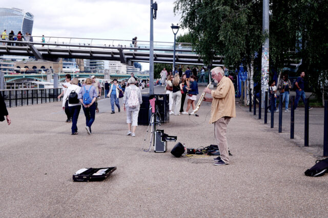 A man playing sax at front of tate modern in uk