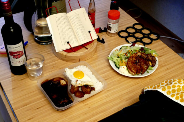 bottled red wine asian food book on the table