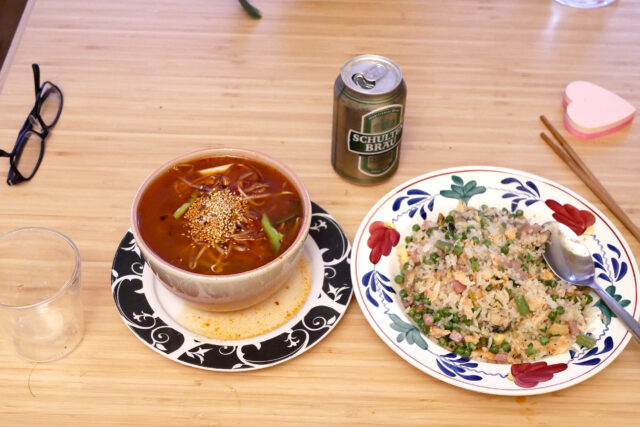 fried rice and ramen noodles and canned beer on the table